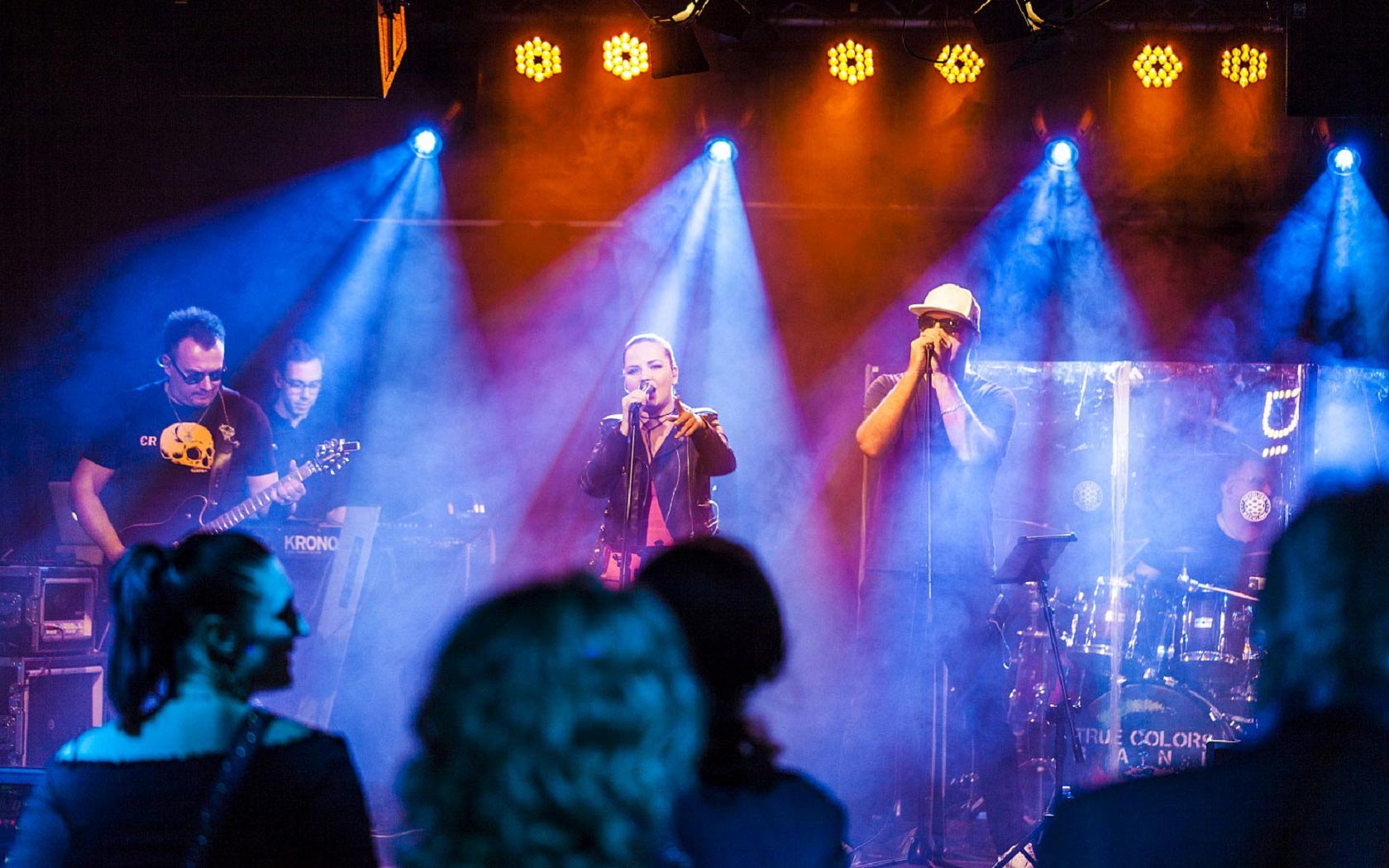 True Colors Cover Band podczas koncertu w sali z pełnym oświetleniem scenicznym